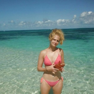 Blondine im Bikini steht im kristallklarem Wasser